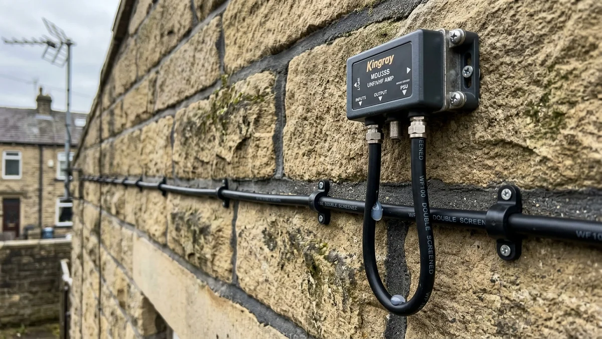 Shielded masthead amplifier and WF100 coax cable routed neatly on Bradford masonry
